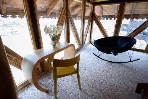 a bathroom with a black tub in a room with windows at Satul Banului Guesthouse in Măgureni
