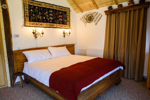 a bedroom with a large bed in a room at Satul Banului Guesthouse in Măgureni
