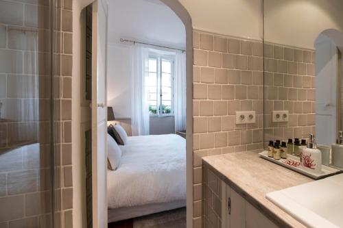 - une chambre avec un lit et une salle de bains avec un miroir dans l'établissement Le Pigeonnier, à Saint-Tropez