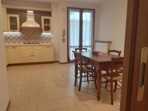 a kitchen with a table and chairs and a stove at Le Betulle Affittacamere in Sona