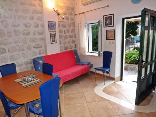 a living room with a red couch and a table at Gudelj Apartments in Perast