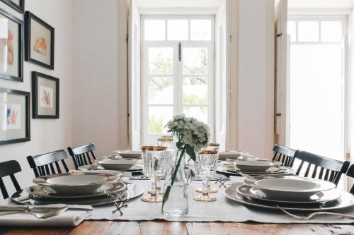a dining room with a table with plates and flowers at São Paulo Boutique Hotel - SPBH in Tavira