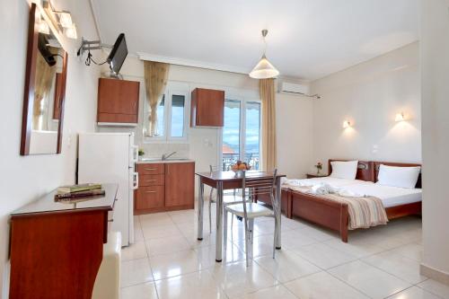 ルトラ・エディプソスにあるNiovi Luxury Apartmentsのキッチン、ベッドルーム(ベッド1台、テーブル付)