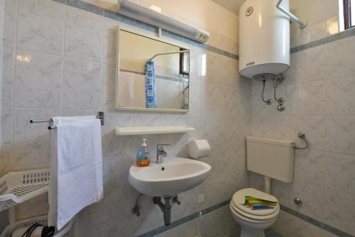 La salle de bains est pourvue d'un lavabo, de toilettes et d'un miroir. dans l'établissement Apartments Ivan 41, à Pula
