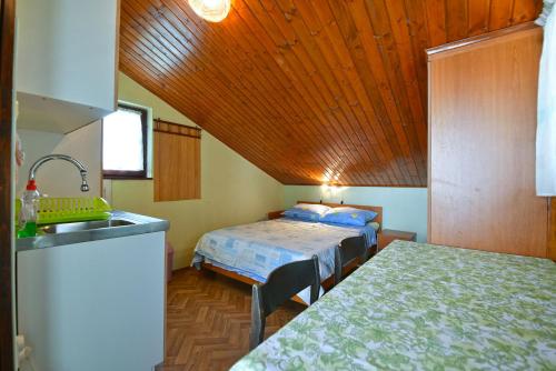 kuchnia z 2 łóżkami i umywalką w pokoju w obiekcie Apartments Ivan 41 w Puli
