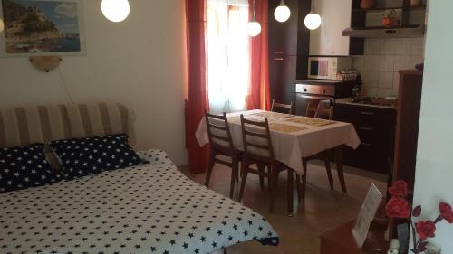 a room with a table and a kitchen with a bed at Charming cozy holliday house 2+2 in Valtura