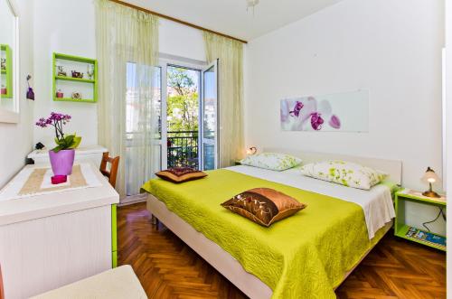 a bedroom with a large bed with a yellow blanket at Rooms Barbarić in Hvar