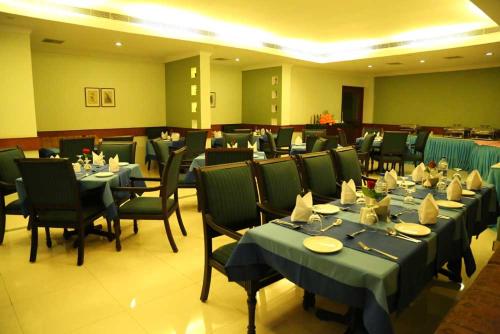 comedor con mesas y sillas y ythonithonon en Kallada hotels, en Trichūr