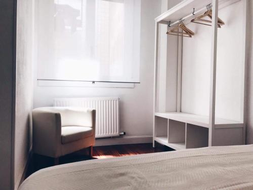 une chambre avec un lit, une chaise et une fenêtre dans l'établissement Muy luminoso en San Mamés, à Bilbao