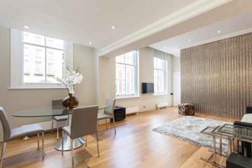 a dining room with a glass table and chairs at The Harrington - Gloucester Road - 3 Harrington Gardens in London