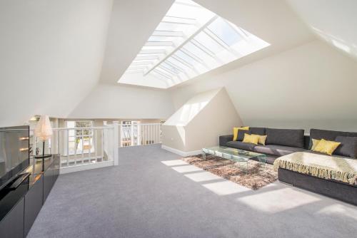 a living room with a couch and a skylight at The Harrington - Gloucester Road - 3 Harrington Gardens in London