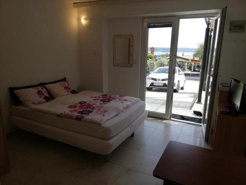 um quarto com uma cama e uma porta de vidro deslizante em Apartments Pronavtik em Piran