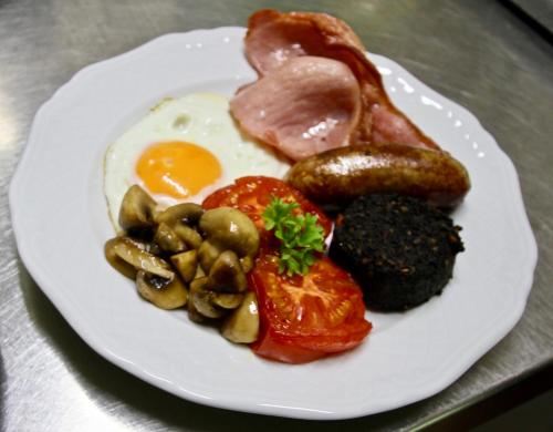 um prato de pequeno-almoço com ovos, cogumelos e carne em Rylstone Manor em Shanklin