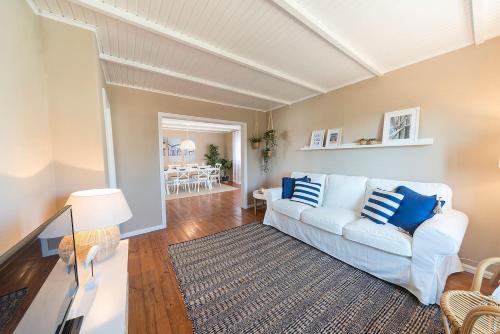 a living room with a white couch and blue pillows at Beachliving Esmoriz in Esmoriz
