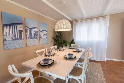 a dining room with a white table and chairs at Beachliving Esmoriz in Esmoriz