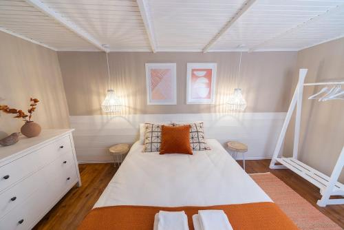 1 dormitorio con 1 cama blanca grande con almohadas de color naranja en Beachliving Esmoriz, en Esmoriz