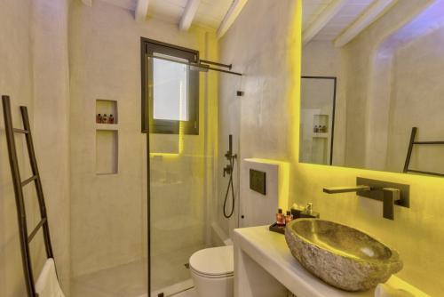 a bathroom with a sink and a shower at Mykonian Mews Luxury Suites in Psarou