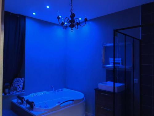 a blue bathroom with a tub and a sink at MANOIR AUX trois charmes in Ronchamp