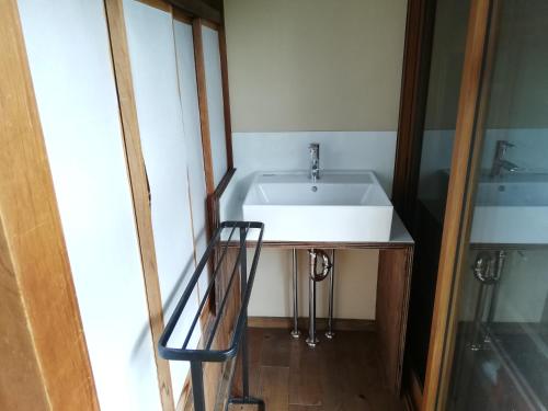 a bathroom with a sink and a mirror at Yuzan Guesthouse in Nara