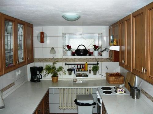 una cucina con ripiani bianchi e mobili in legno di Chata Rozárka a Dolni Dvur
