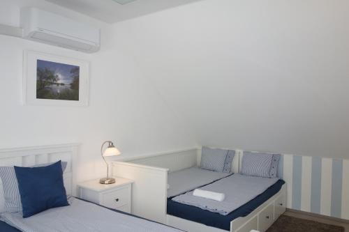 a small bedroom with a bed and a lamp at Lednicko-valtický apartmán in Hlohovec