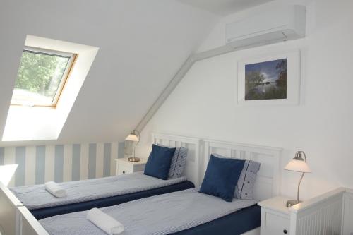 um quarto com 2 camas e almofadas azuis em Lednicko-valtický apartmán em Hlohovec
