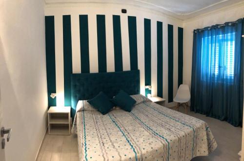 a bedroom with a bed with a striped wall at B&B Scala dei Turchi in Realmonte