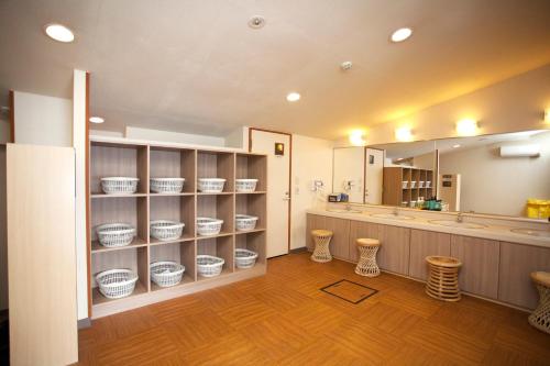 a room with a counter with white bowls on shelves at Hotel Route-Inn Kawaguchiko in Fujikawaguchiko
