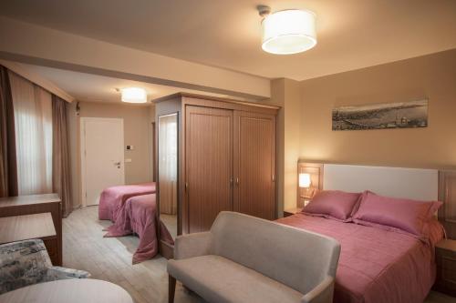 a bedroom with two beds and a couch and a chair at HALİT VARGÜN APART in Istanbul