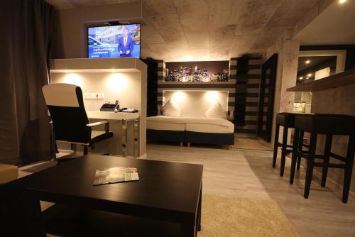 a room with a bed and a table and a tv at SL'otel Budget in Bernburg