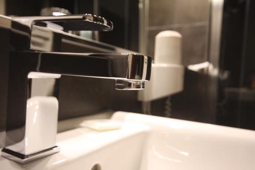 a bathroom sink with a faucet and a mirror at SL'otel Budget in Bernburg