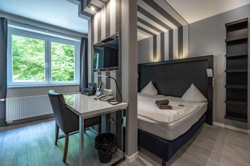 a bedroom with a bed and a desk and a deskablish at SL'otel Budget in Bernburg