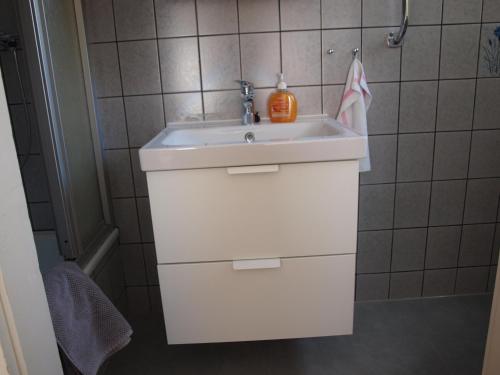 łazienka z umywalką i dozownikiem mydła w obiekcie Muttis Apartment w mieście Mönchengladbach