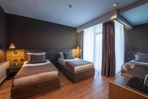 a hotel room with two beds and a window at Seraphine Plaza in Peje