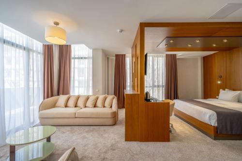a hotel room with a bed and a couch at Hotel Atlas Abashidze in Tbilisi City