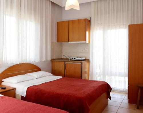 アギア・トリアダにあるNoni Roomsのベッド2台とキッチンが備わるホテルルームです。