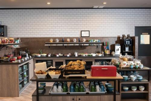 a kitchen with a counter with lots of food at Ramada by Wyndham Flensburg City in Flensburg