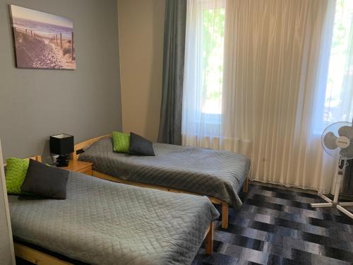 a room with two beds and a window at Portoss in Ventspils