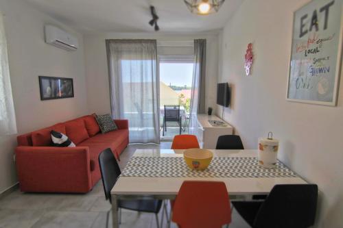 a living room with a red couch and a table at Apartments Luna in Novalja