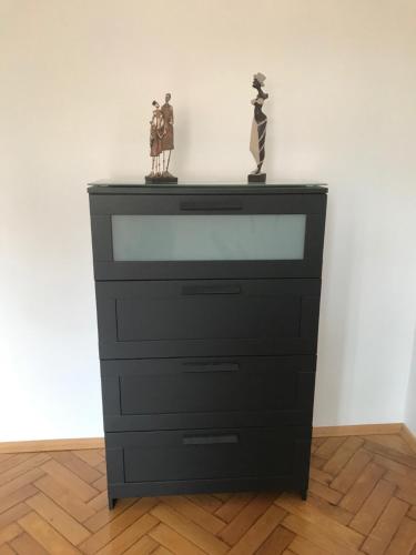 a dresser with two statues on top of it at Lilians modern Appartement in historical Citycenter in Graz