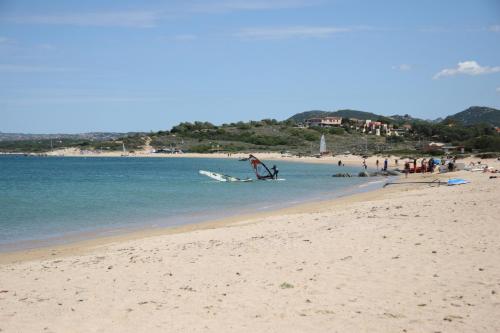 a group of people on a beach with the ocean at Hotel Le Dune in Porto Pollo