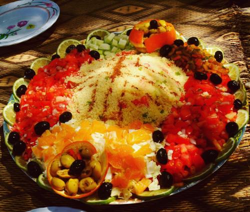 une assiette de fruits et légumes sur une table dans l'établissement Bivouac Mélodie du désert, à M'Hamid El Ghizlane