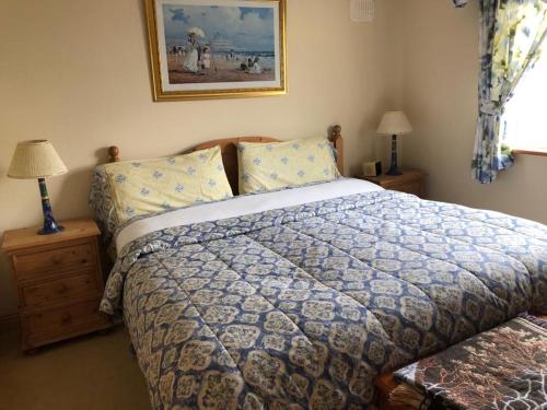 1 dormitorio con 1 cama y 2 mesitas de noche con lámparas en Cliff Cottages en Liscannor