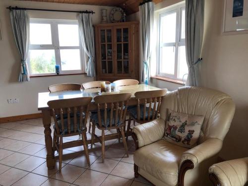 a kitchen with a table and chairs and a couch at Cliff Cottages in Liscannor