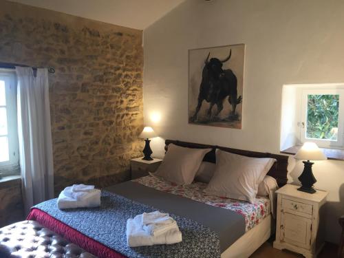 une chambre avec un lit avec deux serviettes dessus dans l'établissement La Fontaine des Oliviers, à Blauzac