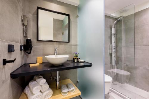 a bathroom with a sink and a shower at Peven Suites in Naousa
