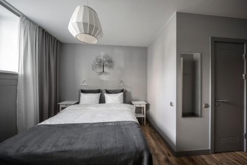 a bedroom with a bed and a pendant light at Hotel Saida - quality hostel in Rīga
