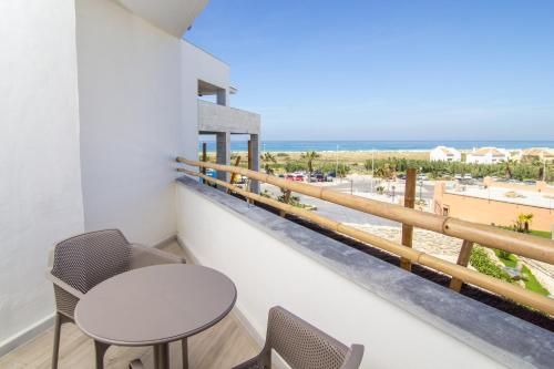 a balcony with a table and chairs and the beach at Zahara Beach & Spa by QHotels - Adults Recommended in Zahara de los Atunes