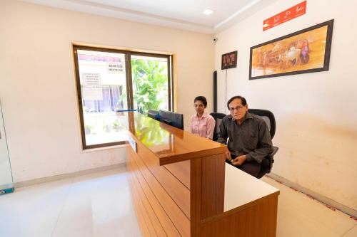 two people sitting at a podium in a room at Vivaant Retreat and Conventions in Igatpuri
