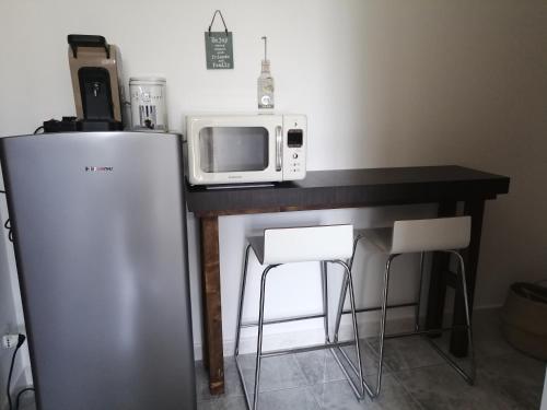 a kitchen with a counter with a microwave and a refrigerator at Casa Grazia in Crispiano